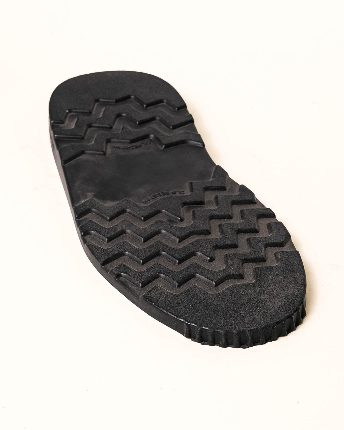 Black wedge with tread showing with white background.