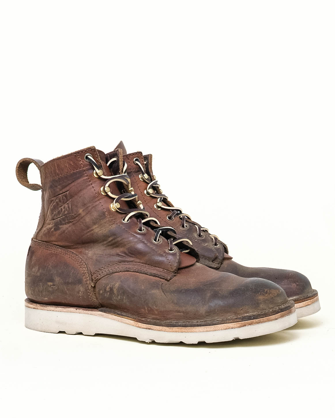 Brown leather SGB boots sitting at 3-quarter angle in front of off-white background. Boot are worn but have new white wedge sole.